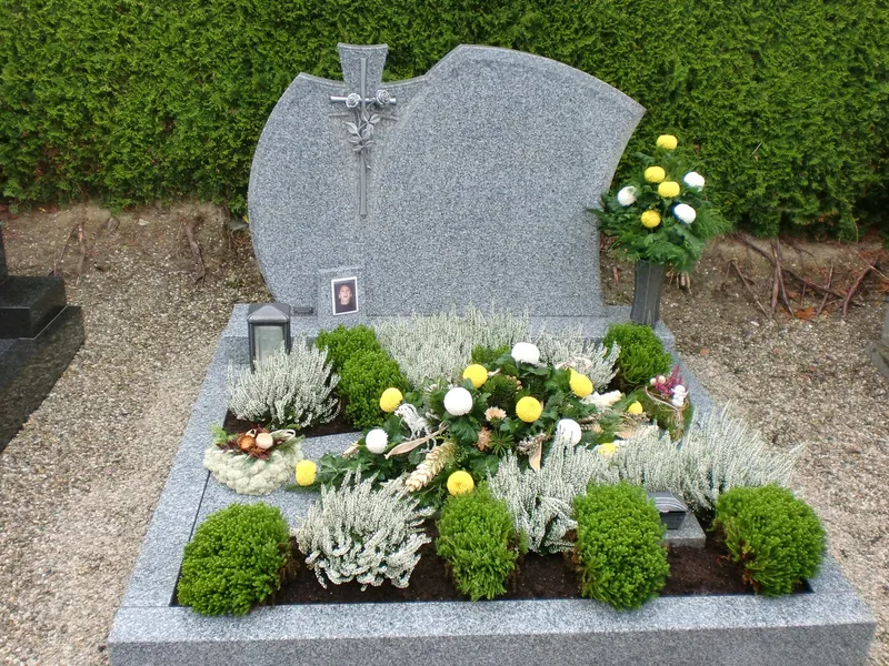 Granitgrab mit Heide, Silberblatt und gelben Chrysanthemen