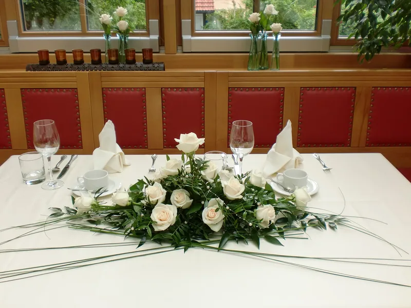 Tafelgesteck aus weißen Rosen auf einer Hochzeitstafel